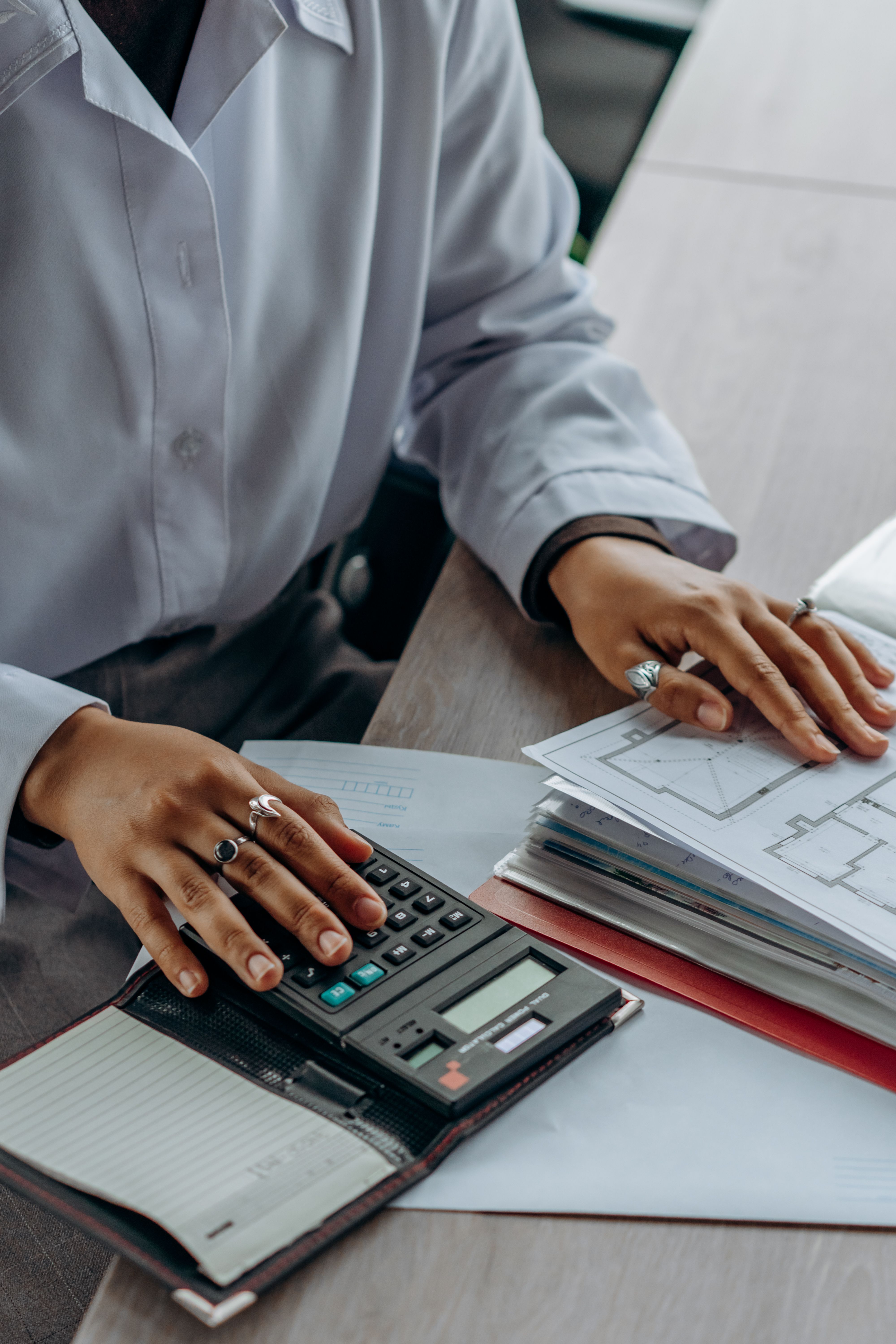 Contador trabalhando com calculadora e documentos financeiros